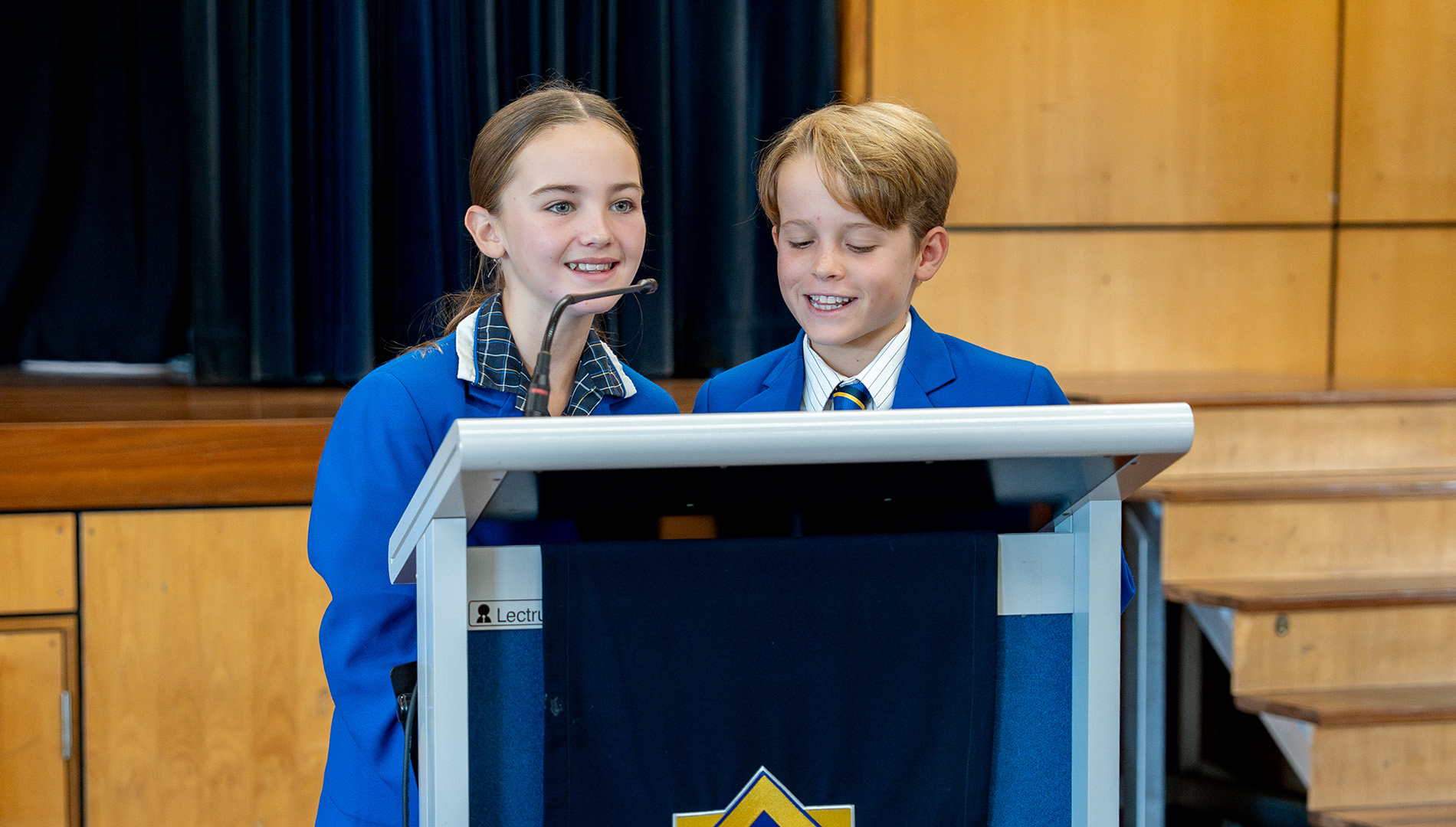 Students speaking at lectern.